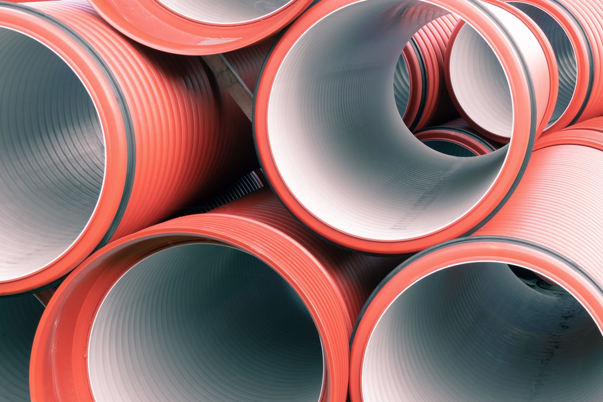 Large-diameter sewer and drainage pipes stacked at a job site