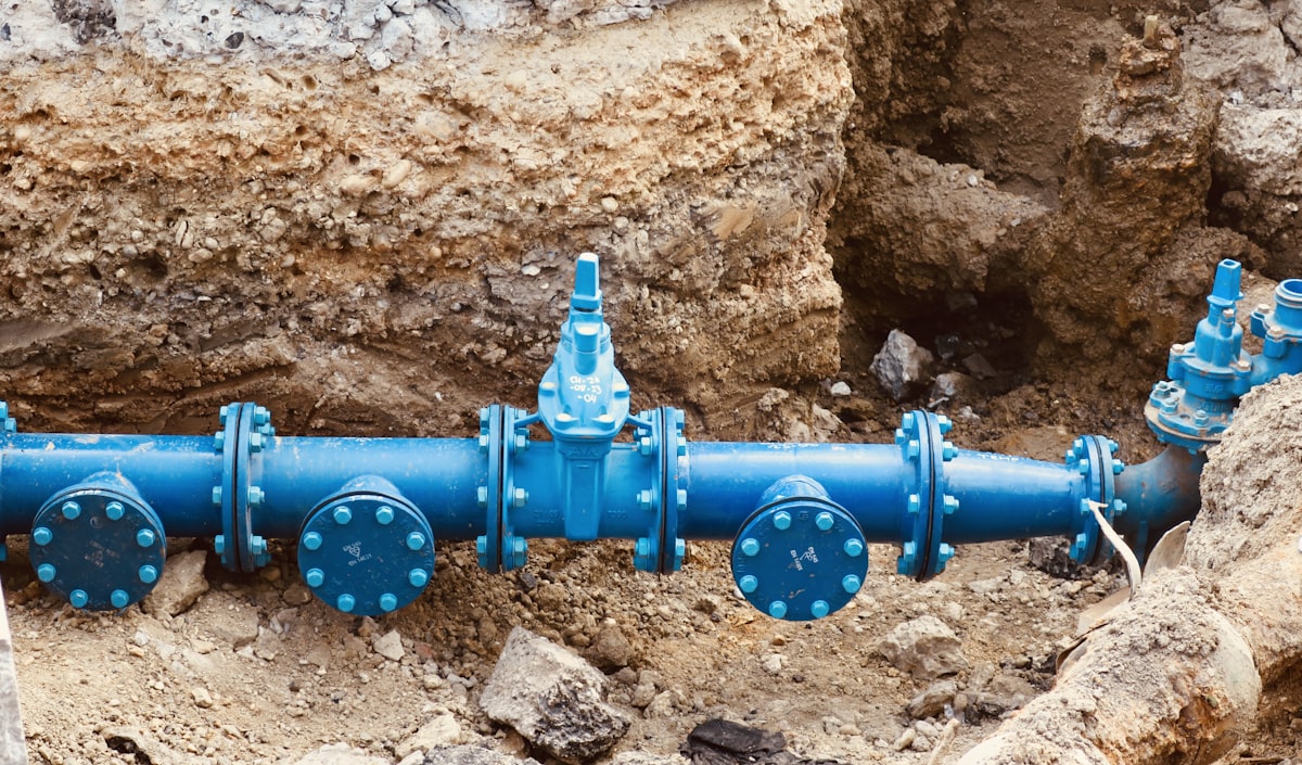 Blue potable water main pipe exposed in an excavation trench